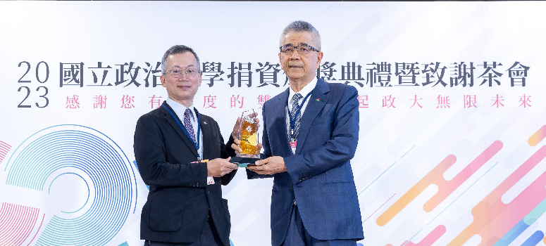 信義企業集團創辦人周俊吉(右)從政大校長李蔡彥手中接下感謝獎座。